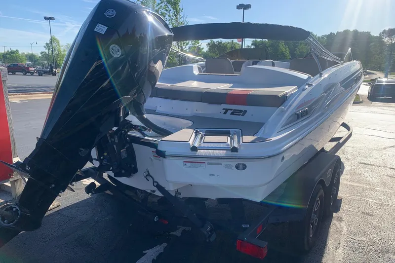 Slide: The Image of 2023 Tahoe T21 boat on trailer with powerful outboard motor in sunny parking lot. - 11