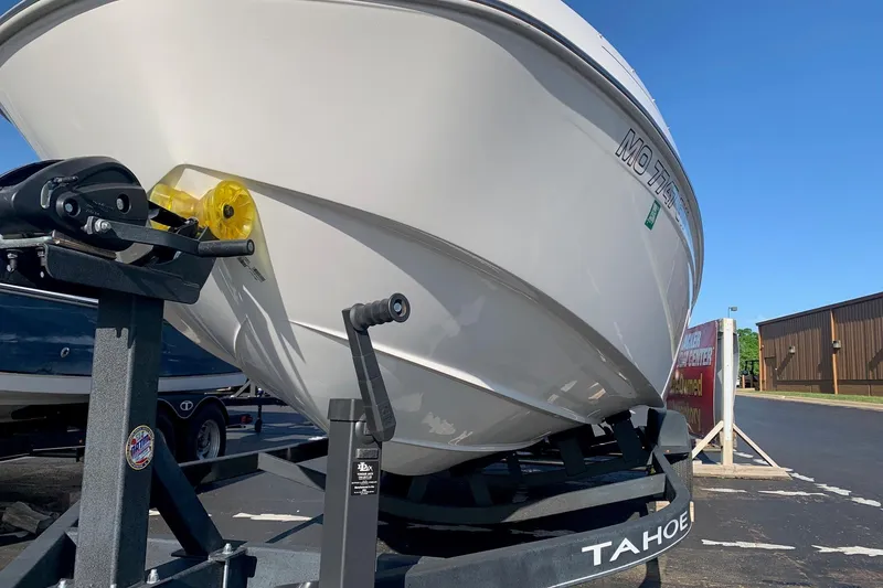 Slide: The Image of 2023 Tahoe T21 boat on trailer under clear blue sky. - 2