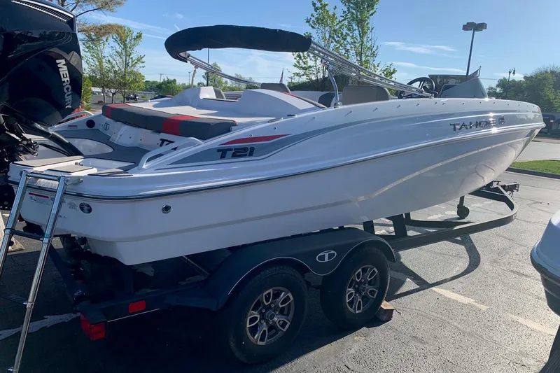 Slide: The Image of 2023 Tahoe T21 boat on trailer, parked outdoors under clear sky. - 3