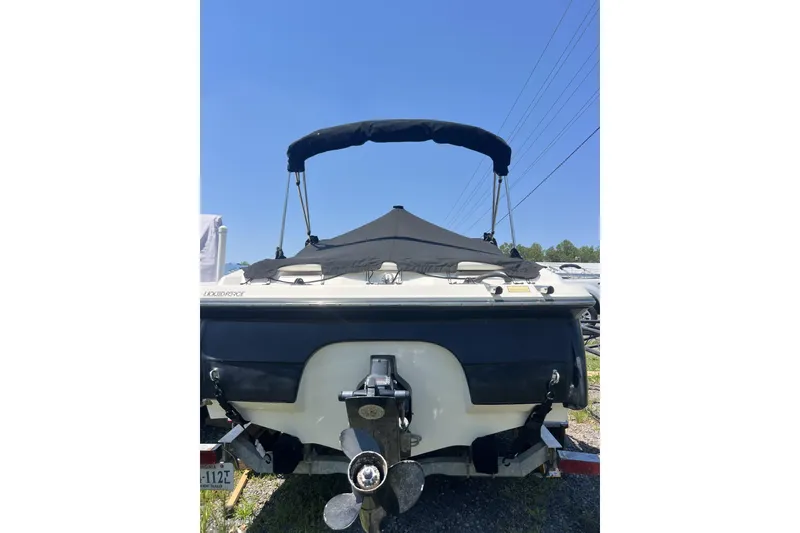 Slide: The Image of 2008 Monterey 180FS boat with black canopy and propeller, parked outdoors. - 2