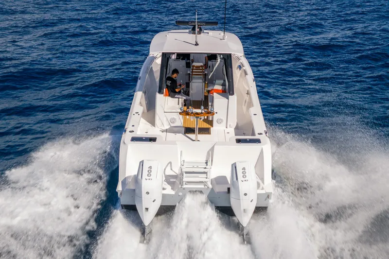 Slide: The Image of 2026 Hammer Yachts 35HH cruising on open water, rear view with dual engines. - 2