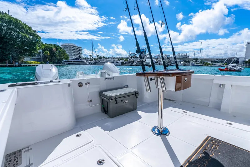 Slide: The Image of 2026 Hammer Yachts 35HH boat deck with fishing rods, cooler, and scenic marina view. - 33