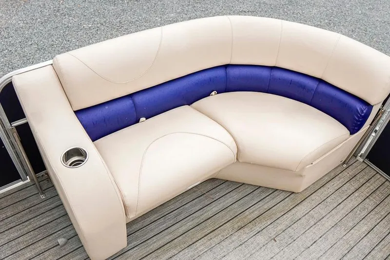 Slide: The Image of Cream and blue seating on 2012 Xcursion X21C boat, featuring a built-in cup holder. - 10