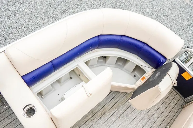 Slide: The Image of 2012 Xcursion X21C boat interior with curved seating and storage compartment. - 12
