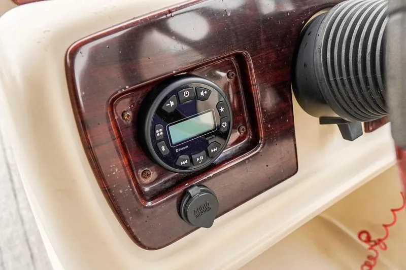 Slide: The Image of Control panel of a 2012 Xcursion X21C boat featuring audio system and accessory port. - 17