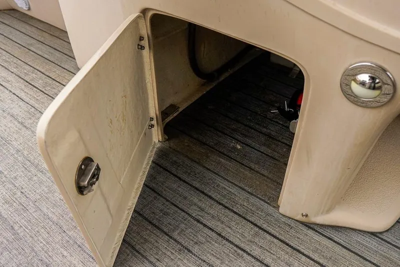Slide: The Image of Open storage compartment on 2012 Xcursion X21C boat with visible interior details. - 23