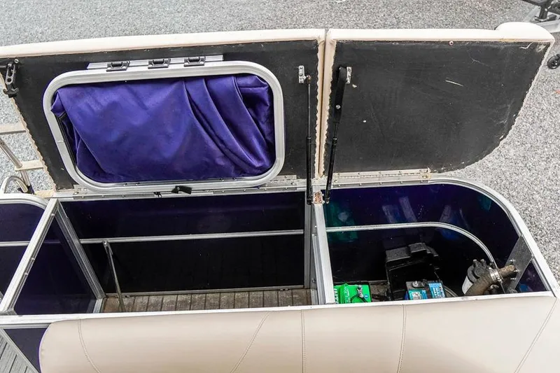 Slide: The Image of Open storage compartment in 2012 Xcursion X21C boat, revealing interior components and equipment. - 25