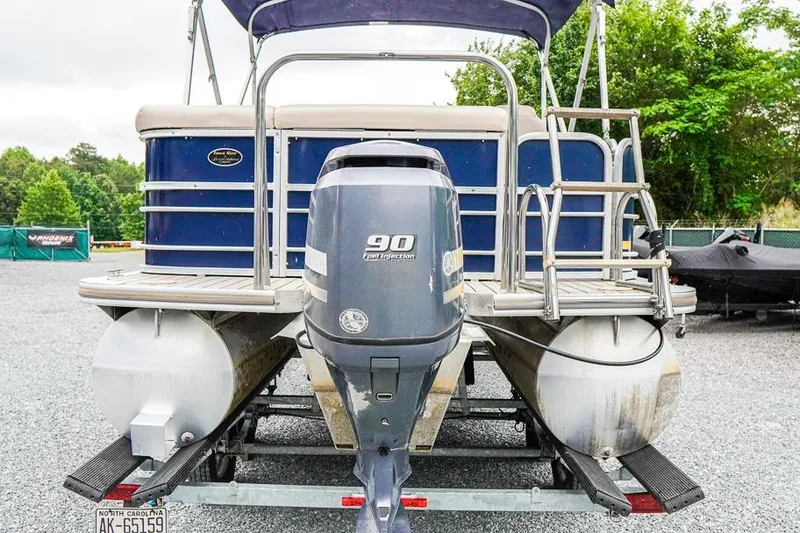 Slide: The Image of 2012 Xcursion X21C pontoon boat with 90 HP outboard motor, parked on trailer. - 4