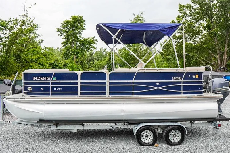 Slide: The Image of 2012 Xcursion X21C pontoon boat on trailer with blue canopy, parked outdoors. - 5