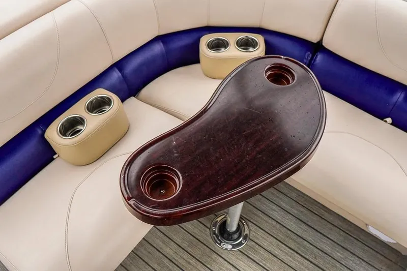 Slide: The Image of Luxurious seating area on 2012 Xcursion X21C boat with cup holders and wooden table. - 7