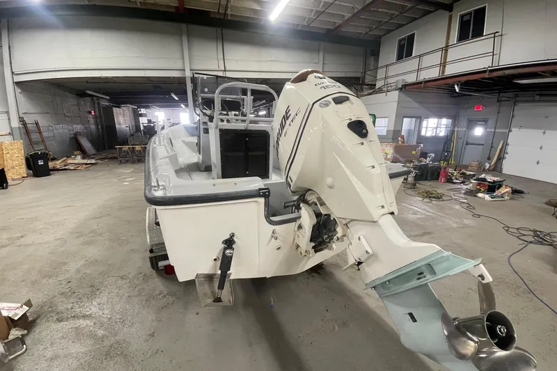 Slide: The Image of 1995 Boston Whaler Justice boat with Evinrude outboard motor in a workshop setting. - 3