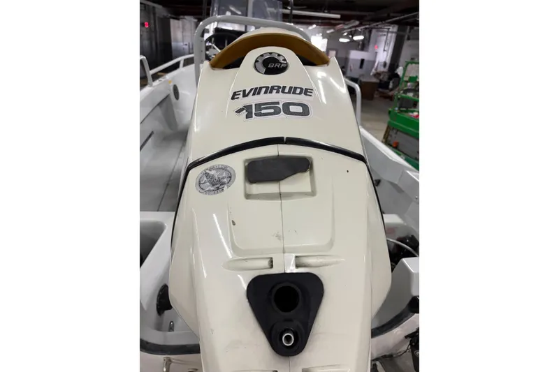 Slide: The Image of 1995 Boston Whaler Justice boat with Evinrude 150 outboard motor in a garage. - 9