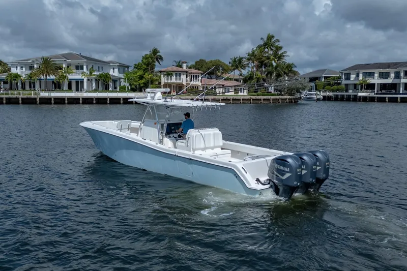 Slide: The Image of 2017 Invincible 39 Open Fisherman boat cruising near waterfront homes. - 14