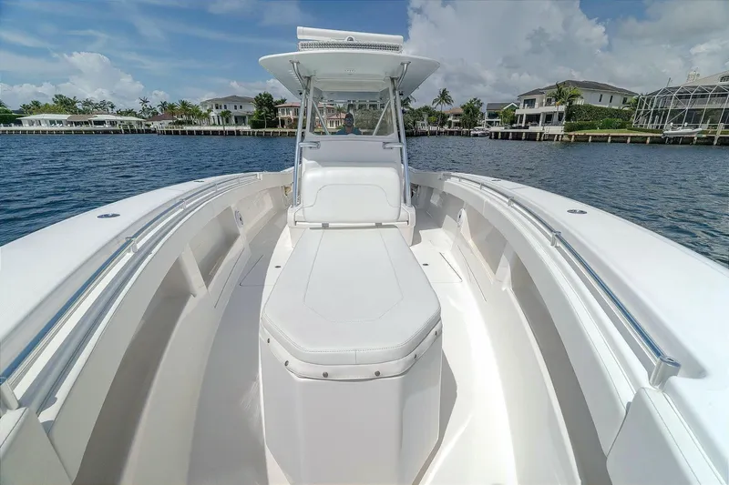 Slide: The Image of 2017 Invincible 39 Open Fisherman boat on calm water, showcasing spacious deck and sleek design. - 2