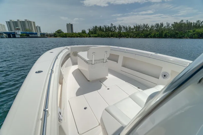 Slide: The Image of 2017 Invincible 39 Open Fisherman boat on calm water, cityscape in background. - 22