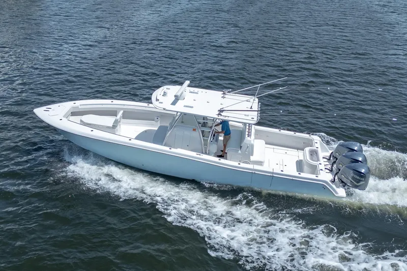 Slide: The Image of 2017 Invincible 39 Open Fisherman boat cruising on water with triple outboard engines. - 4