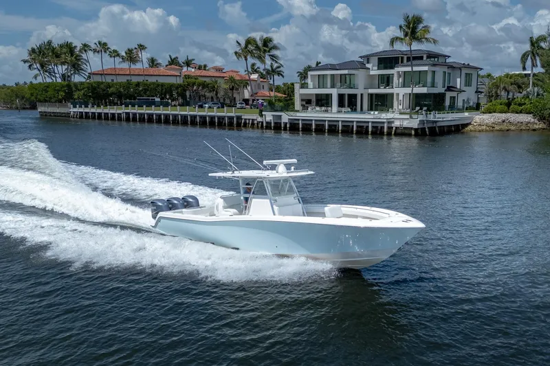 Slide: The Image of 2017 Invincible 39 Open Fisherman boat cruising near luxury waterfront homes. - 6