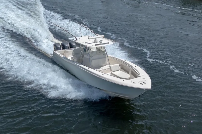 Slide: The Image of 2017 Invincible 39 Open Fisherman boat cruising on water with triple engines. - 7