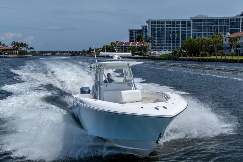 Slide: The Image of 2017 Invincible 39 Open Fisherman cruising on a waterway near modern buildings. - 8