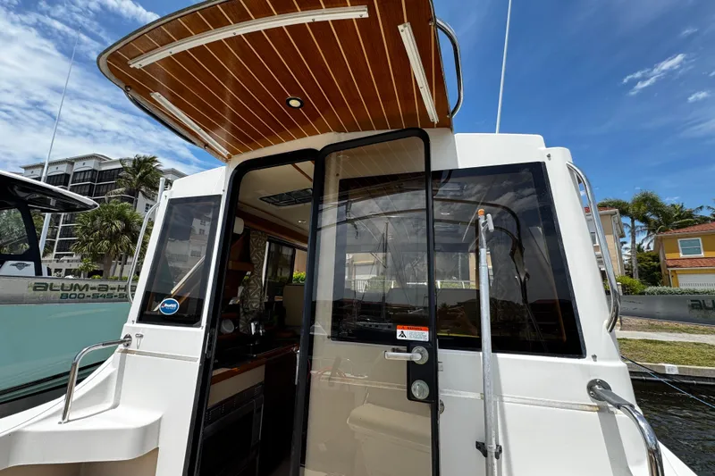 Slide: The Image of 2012 Cutwater C-26 boat with wooden ceiling, docked near waterfront homes. - 10