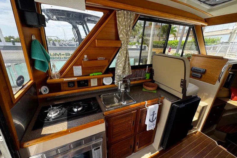 Slide: The Image of Interior of a 2012 Cutwater C-26 boat featuring a compact kitchen area. - 12