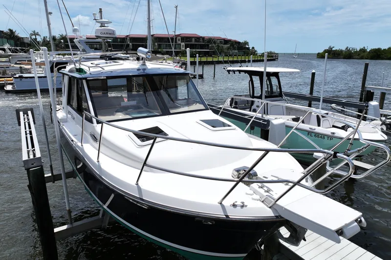 Slide: The Image of 2012 Cutwater C-26 boat docked at marina, surrounded by other vessels. - 2