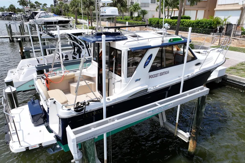 Slide: The Image of 2012 Cutwater C-26 boat docked on a lift in a marina setting. - 3