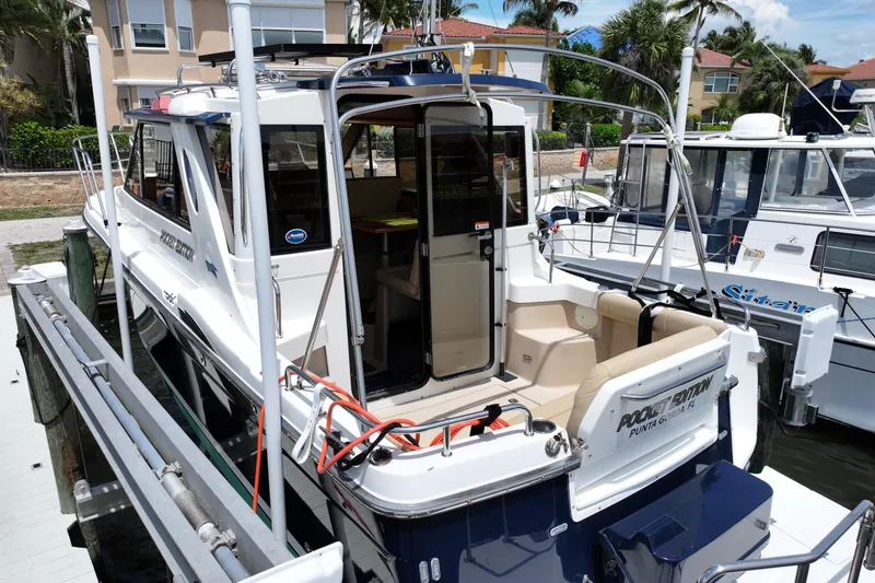 Slide: The Image of 2012 Cutwater C-26 boat docked, featuring open cabin and seating area. - 5