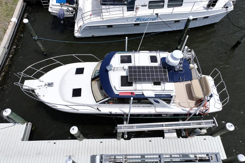 Slide: The Image of 2012 Cutwater C-26 boat docked, featuring solar panels and spacious deck. - 6