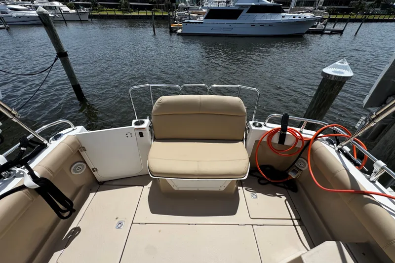 Slide: The Image of 2012 Cutwater C-26 boat deck with beige seating, docked at a marina. - 8