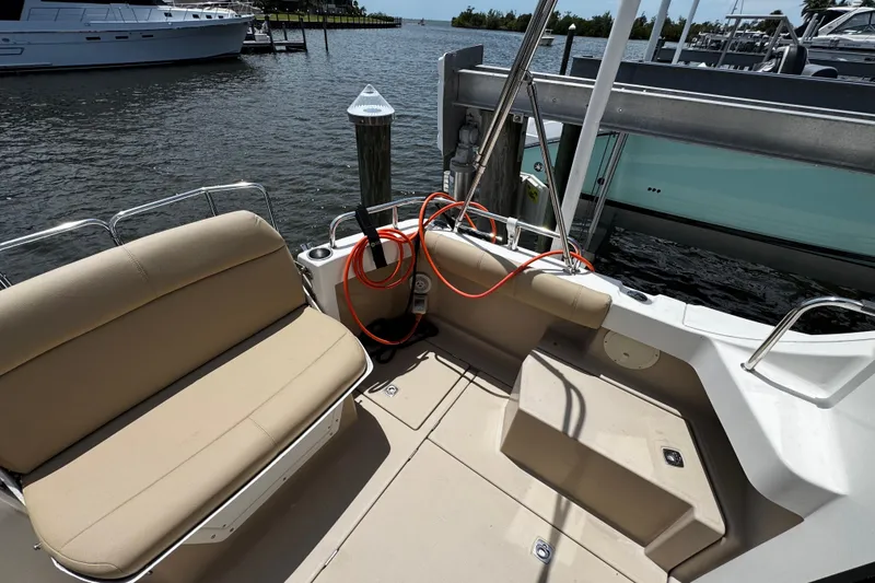 Slide: The Image of 2012 Cutwater C-26 boat interior with beige seating, docked by the water. - 9