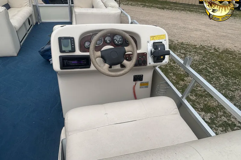 Slide: The Image of 2002 Odyssey Pontoons 2303L boat interior with steering wheel and control panel. - 10