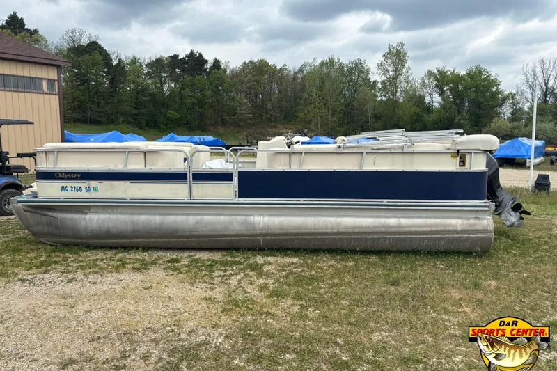Slide: The Image of 2002 Odyssey Pontoons 2303L pontoon boat parked on grass with trees in the background. - 5