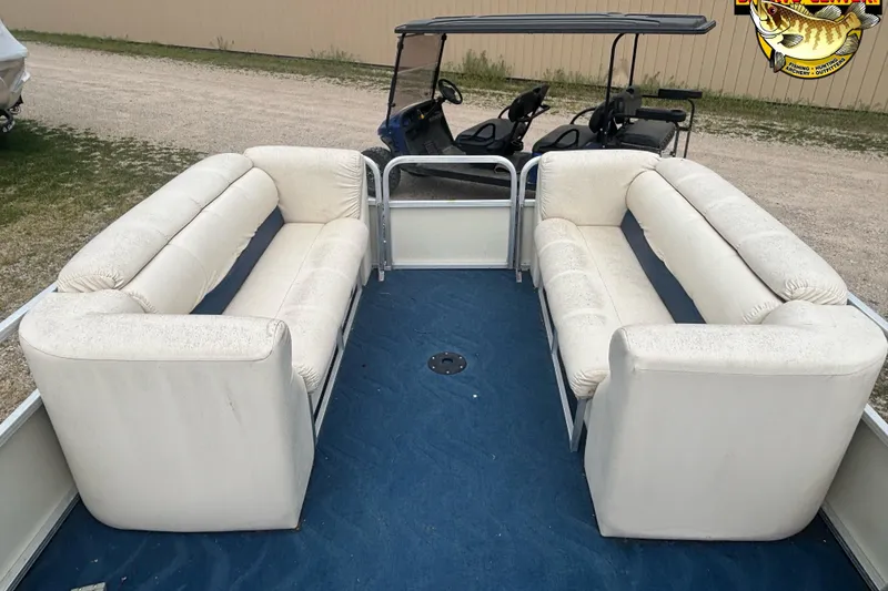 Slide: The Image of 2002 Odyssey Pontoons 2303L interior with white seating and blue carpet. - 9