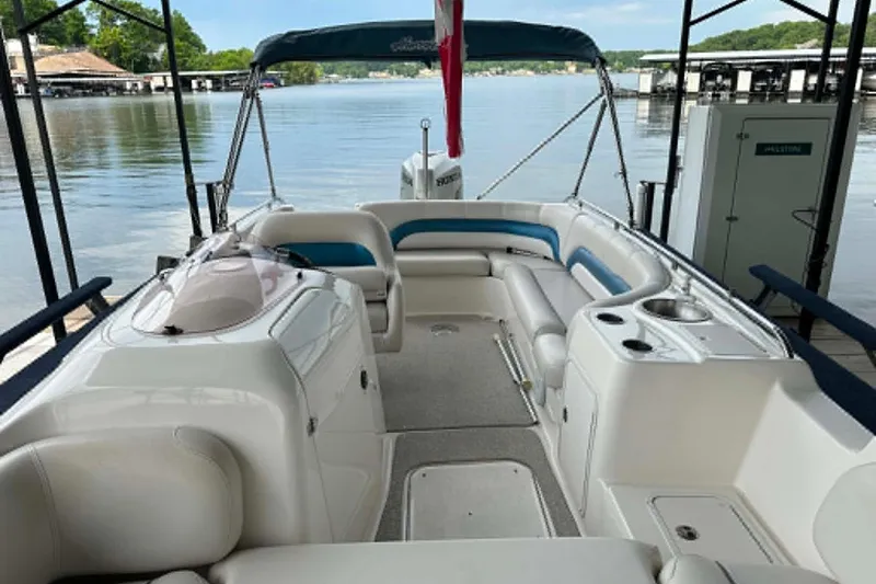 Slide: The Image of 2006 Hurricane FunDeck GS 232 OB boat interior with seating, docked by a serene lake. - 1