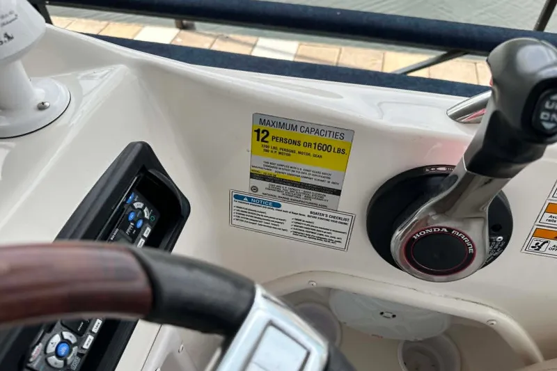 Slide: The Image of 2006 Hurricane FunDeck GS 232 OB boat dashboard with capacity label and Honda Marine throttle. - 12