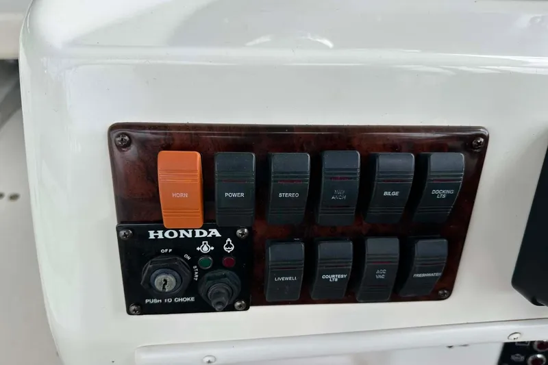 Slide: The Image of Control panel of a 2006 Hurricane FunDeck GS 232 OB boat with various switches and Honda ignition. - 18