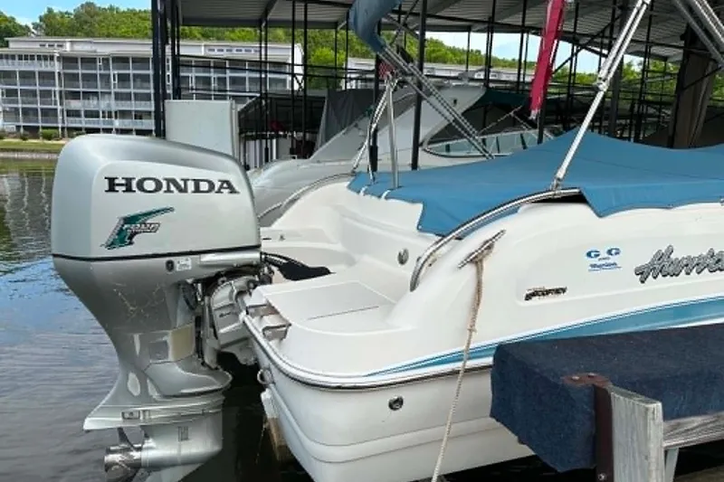 Slide: The Image of 2006 Hurricane FunDeck GS 232 OB boat with Honda outboard motor, docked under a canopy. - 20