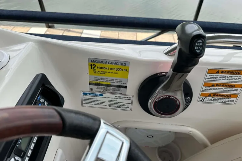 Slide: The Image of 2006 Hurricane FunDeck GS 232 OB boat controls with capacity warning labels and Honda Marine throttle. - 3