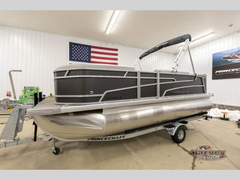Slide: The Image of 2026 Vectra Classic 19 L pontoon boat in a garage with US flag. - 8