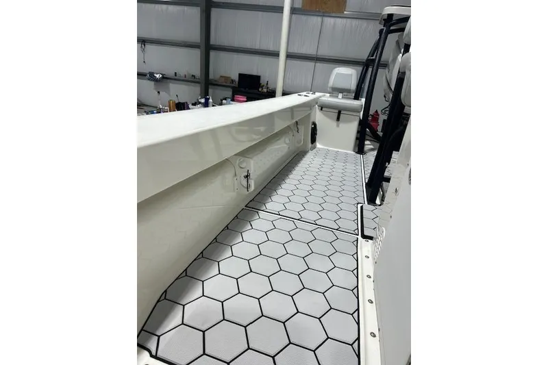 Slide: The Image of 2020 KenCraft 239 Bay Rider boat interior with hexagonal patterned flooring in a garage setting. - 12