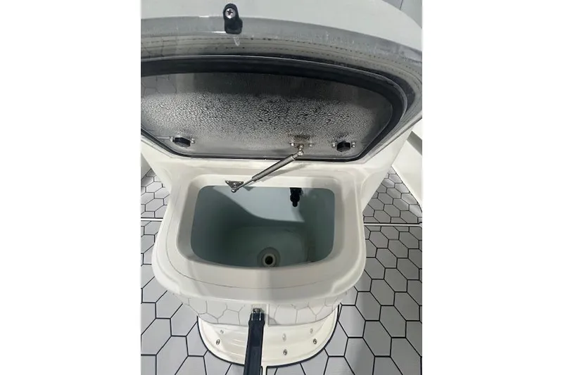 Slide: The Image of Open storage compartment on a 2020 KenCraft 239 Bay Rider boat, featuring hexagonal flooring. - 16