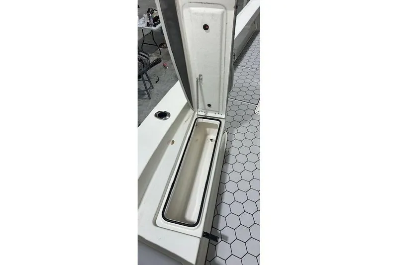 Slide: The Image of Open storage compartment on 2020 KenCraft 239 Bay Rider boat, hexagonal floor tiles visible. - 19