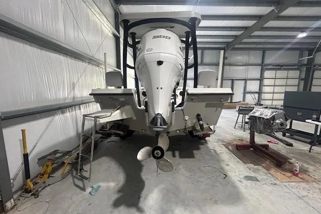 Slide: The Image of 2020 KenCraft 239 Bay Rider boat in a garage, showcasing its powerful outboard motor. - 3