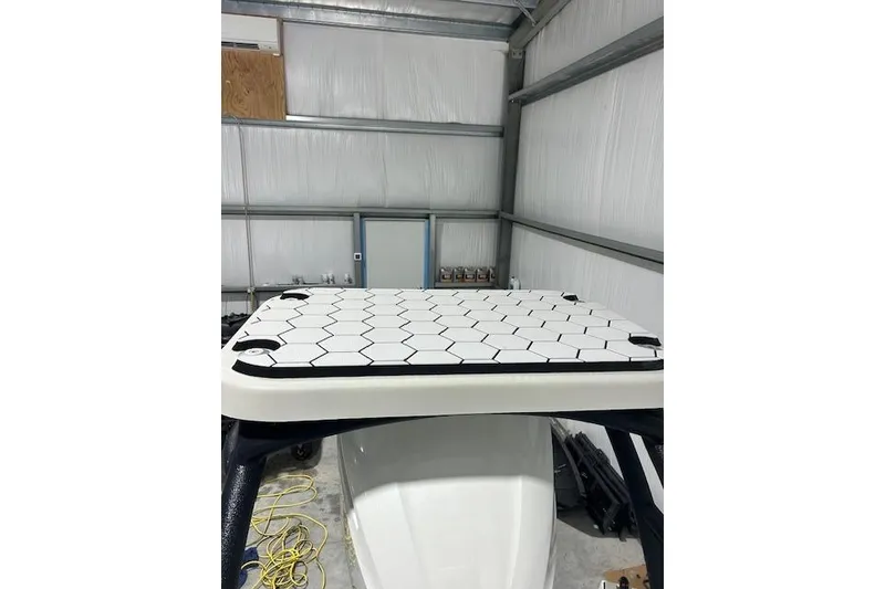 Slide: The Image of 2020 KenCraft 239 Bay Rider boat with hexagonal pattern deck in a storage facility. - 5