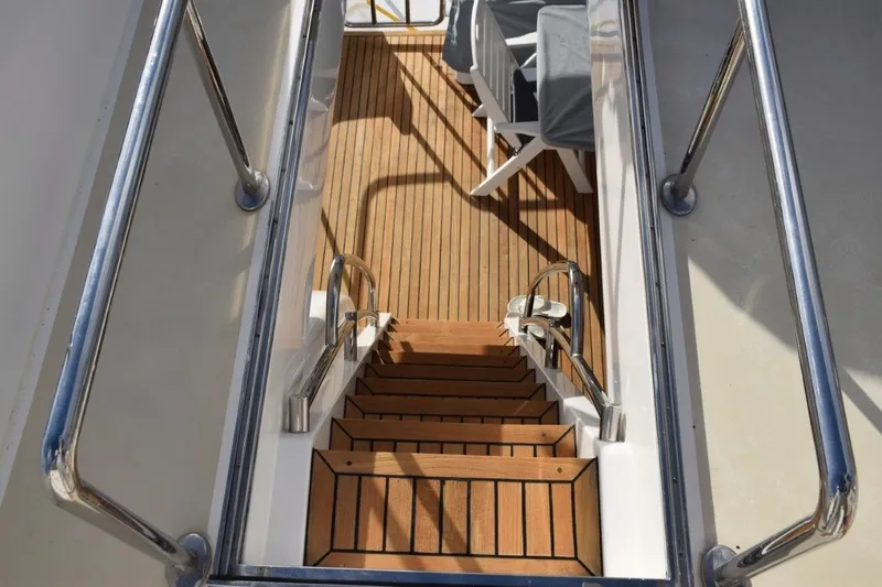 Slide: The Image of Staircase on 2013 Hargrave 76 Open Bridge yacht with teak decking and metal railings. - 48