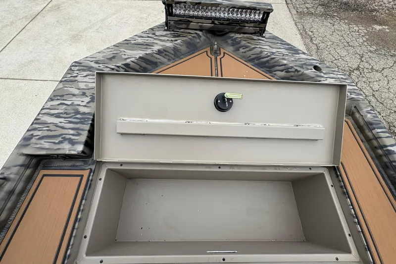 Slide: The Image of Open storage compartment on 2026 Excel 1860 F4 Pro boat with camo design. - 10