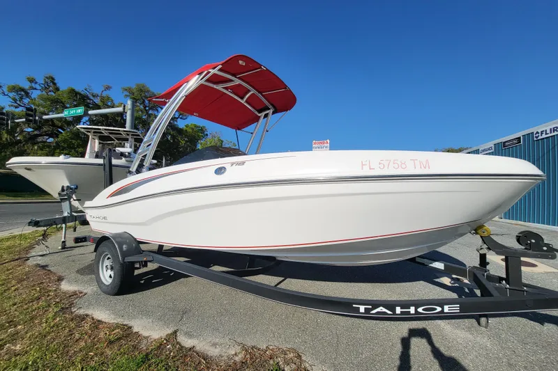The Image of 2023 Tahoe T18 boat with red canopy on trailer, parked outdoors. - 0