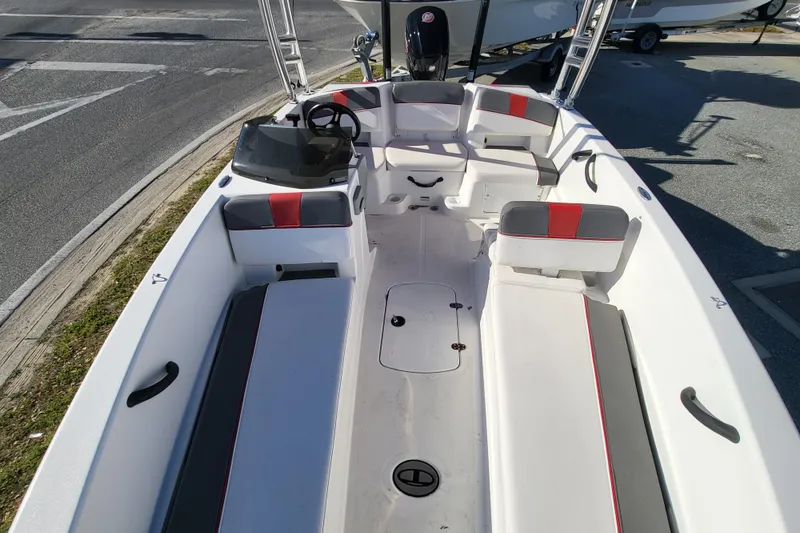 Slide: The Image of 2023 Tahoe T18 boat interior with seating and steering wheel, parked on pavement. - 4