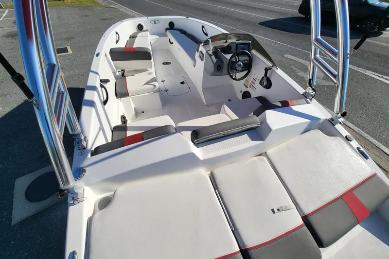 Slide: The Image of 2023 Tahoe T18 boat interior with seating and steering console, parked on pavement. - 5